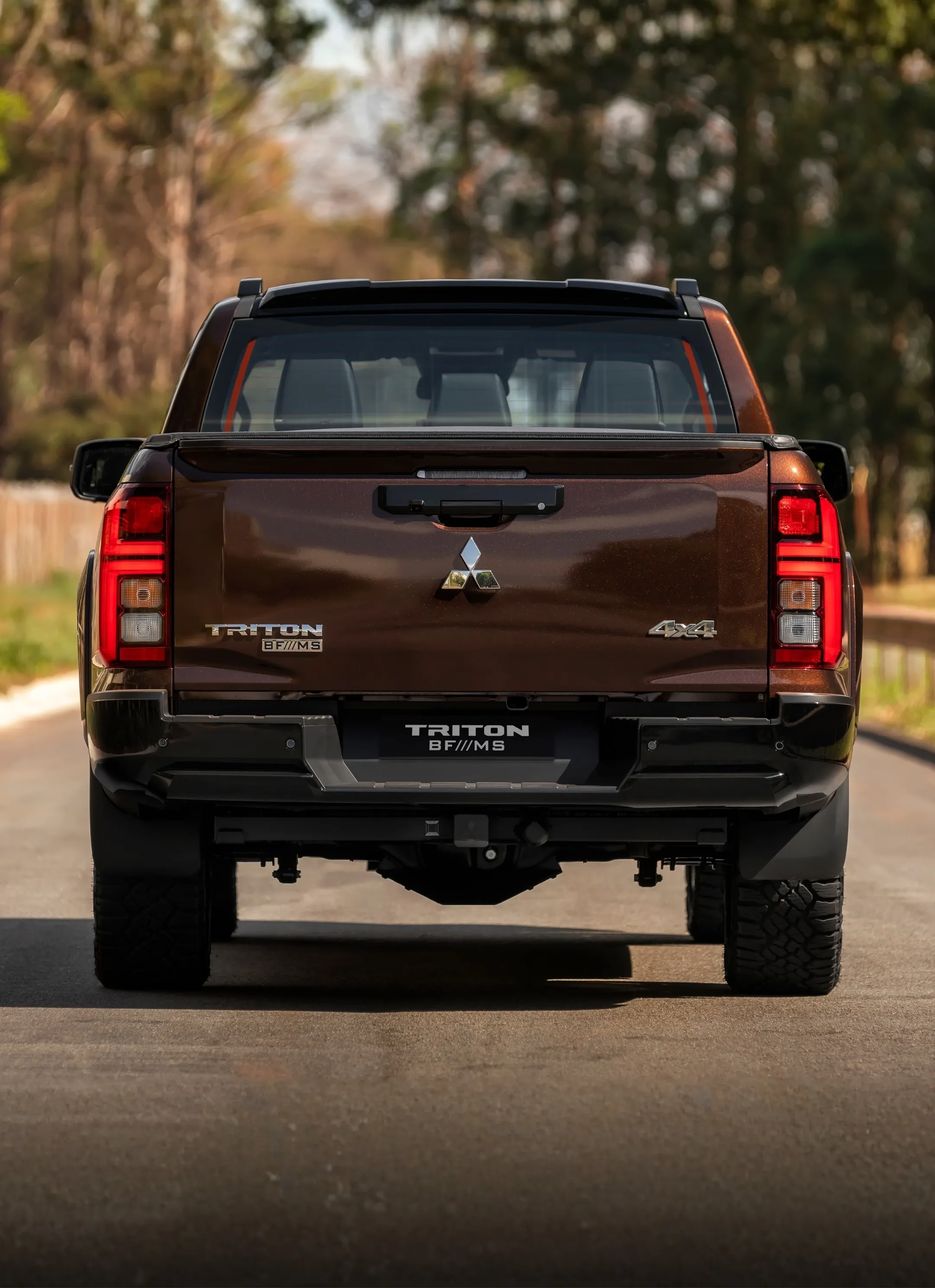 Traseira da Triton BF///MS com lanternas acesas na trilha