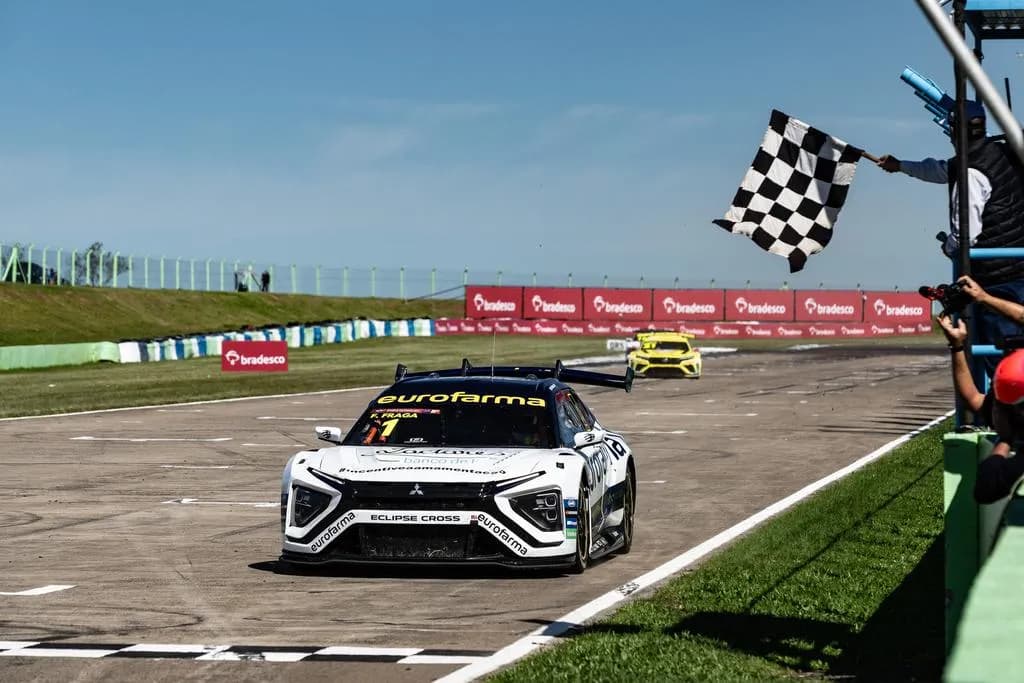 Carro de corrida branco com a carroceria do Eclipse Cross cruzando a linha de chegada sob a bandeira quadriculada